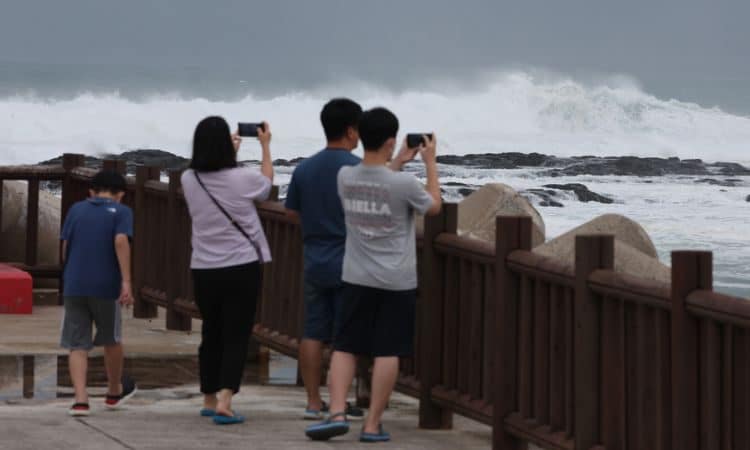 Turistas toman fotografías a las olas de gran tamaño